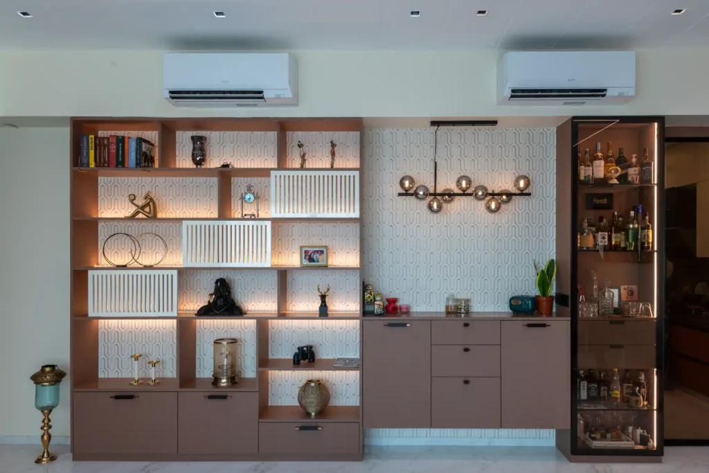 Wall of backlit display shelves beside a glass-fronted bar cabinet and globe pendant light